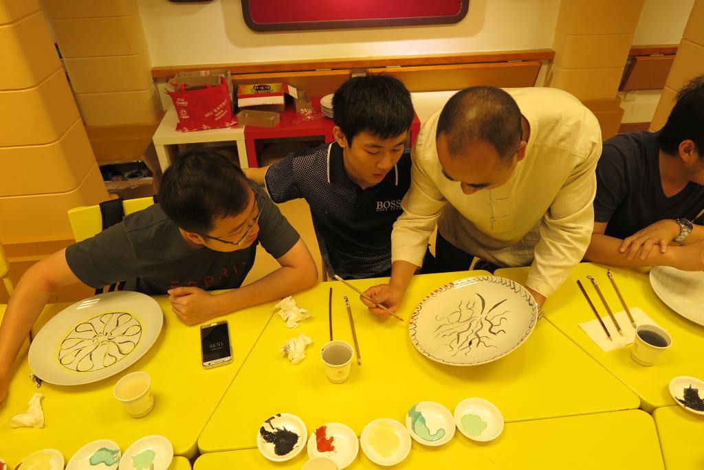 非遗传承人谭广辉老师向留学生传授绘画技巧