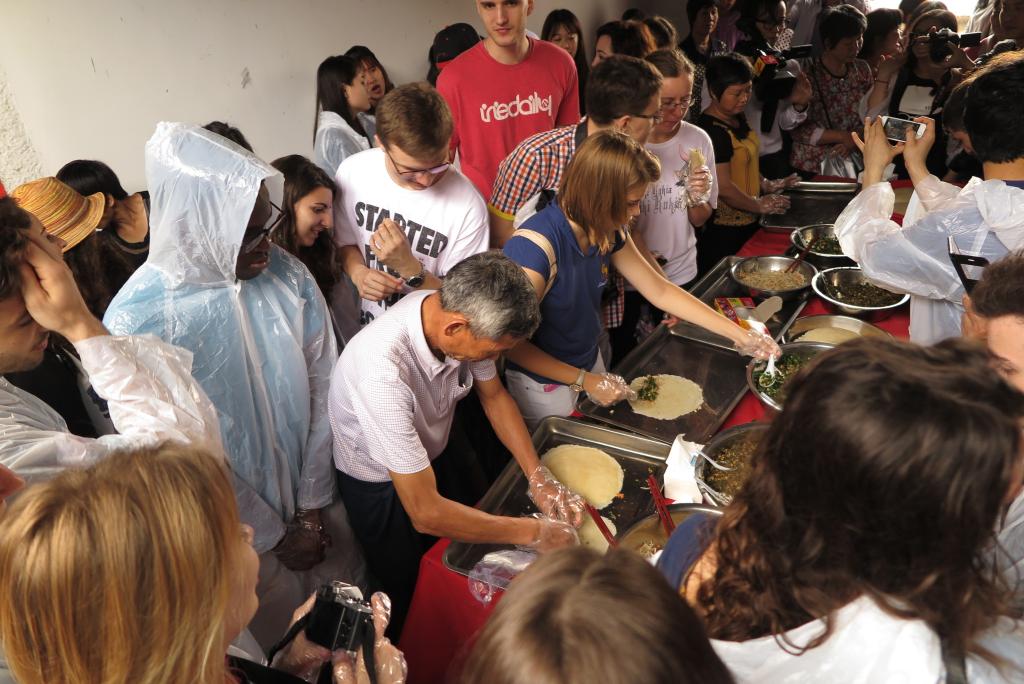 留学生们在村民指导下制作烙面饼